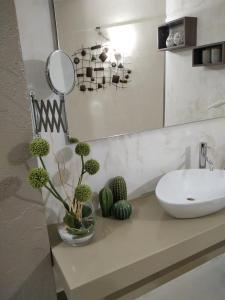 ein Bad mit einem Waschbecken und einem Spiegel in der Unterkunft B&B Radici in Melendugno