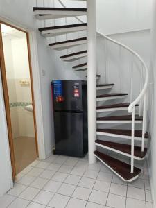 a stairway with a black refrigerator next to a staircase at PD Paradise Lagoon North Penthouse B-2-4 in Kampong Baharu
