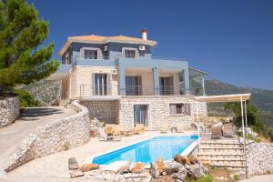 a villa with a swimming pool and a house at marmar villas in Vlikhón