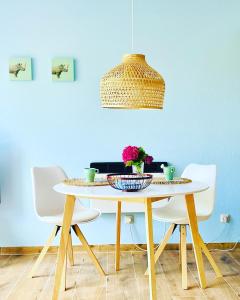 mesa de comedor con sillas y lámpara colgante en Feriengut Neuhof, en Fehmarn