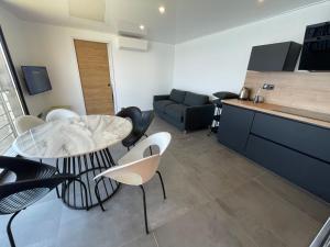 eine Küche und ein Wohnzimmer mit Tisch und Stühlen in der Unterkunft maison de bord de mer cap corse in Santa-Maria-di-Lota
