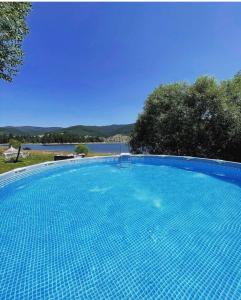 uma grande piscina azul ao lado de um lago em VIP Complex em Sarnitsa