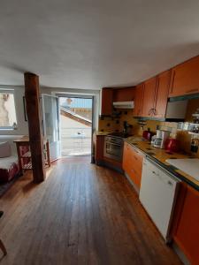 cocina con suelo de madera y ventana grande en La Belle Epoque - au coeur de la Cité médiévale, en Briançon