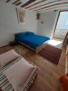 1 dormitorio con 1 cama azul y 2 alfombras en La Belle Epoque - au coeur de la Cité médiévale en Briançon
