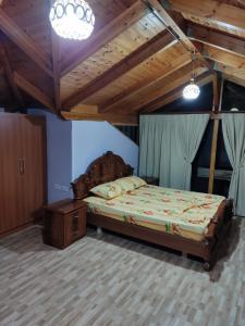 a bedroom with a large bed with a wooden headboard at Lovely 1 - bedroom loft with free parking in Gjirokastër