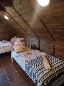 a bedroom with two beds in a wooden cabin at Dom Wakacyjny Krawno in Piecki