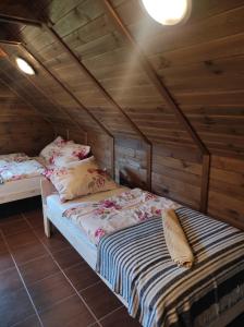 a bedroom with two beds in a wooden cabin at Dom Wakacyjny Krawno in Piecki