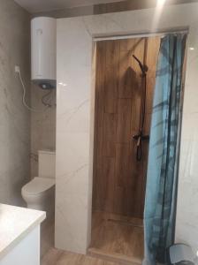 a bathroom with a shower with a wooden door at Dom Wakacyjny Krawno in Piecki