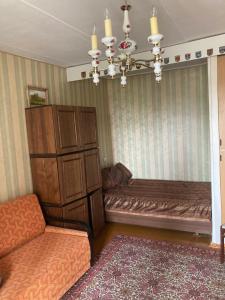 Una sala de estar con un sofá y una lámpara de araña. en Back to USSR, en Sillamäe