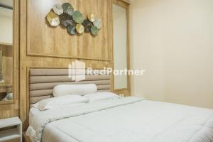 a bedroom with a white bed and a mirror at Guest House B Fren Syariah Near JIH Yogyakarta Mitra RedDoorz in Seturan