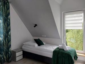 a small bedroom with a bed and a window at Apartament okno na Giewont in Kościelisko
