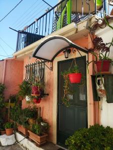 a house with a black door and potted plants at Irene's loft in Ágios Matthaíos