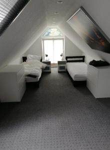 エッセンにあるFerienwohnung Zollvereinのベッド2台と窓が備わる屋根裏部屋です。