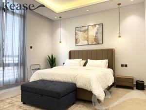 a bedroom with a large bed with a black ottoman at Kease Malqa B-11 Royal touch AZ60 in Riyadh