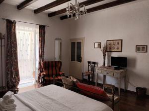 a bedroom with a bed and a desk and a chair at A casa del Nonno in Isnello