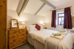 una camera con due letti, uno specchio e un comò di Croft Farm & Celtic Cottages a Cardigan Altre 68 foto