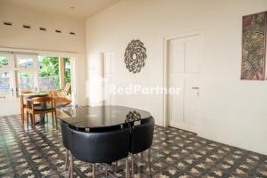 a room with a glass table and a dining room at Villa Dora Jogja near Malioboro Area Mitra RedDoorz in Sentool