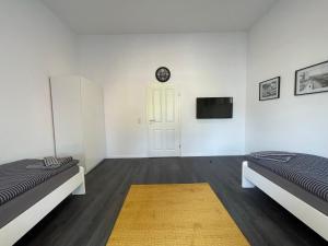 Dieses weiße Zimmer verfügt über 2 Betten und einen TV. in der Unterkunft Herne Zentral Apartment in Herne