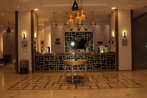 a bar with a stool in the middle of a lobby at alfakhama almasia Serviced Apartments in Medina