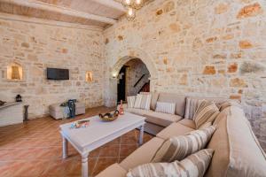 a living room with a couch and a table at Villa Rizolia Epta by Villa Plus in Lithakia