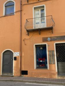 un edificio arancione con balcone e finestra di Maestrale a Tertenìa