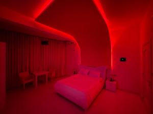 Habitación roja con cama y luces rojas en Grand Hotel Gjyshi, en Qerrexhias