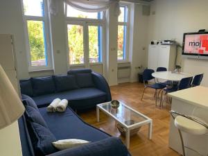 uma sala de estar com um sofá azul e uma mesa em Apartman Villa Klein em Opatija