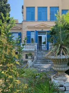 uma casa com janelas azuis e uma escada em frente em Apartman Villa Klein em Opatija