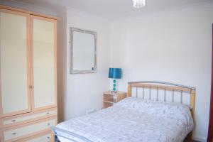 een slaapkamer met een bed en een dressoir bij Near Sea House Stay in Bangor