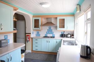 a kitchen with blue cabinets and a sink at Near Sea House Stay in Bangor