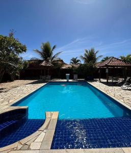 a large blue swimming pool in a resort at Pousada Encanto dos Anjos in Pirenópolis