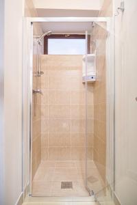 a shower with a glass door in a bathroom at Dom Unirii Apartment in Timişoara
