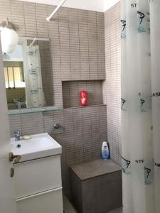 SaronidaにあるSaronida beach apartments kids and pets friendlyの洗面台と鏡付きシャワーを備えたバスルーム