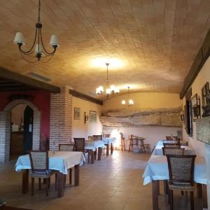 a restaurant with tables and chairs and a ceiling at La Contrada in Arens de Lledó