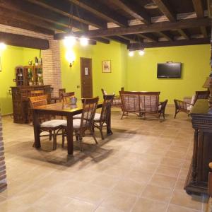a dining room with a table and chairs and a tv at La Contrada in Arens de Lledó