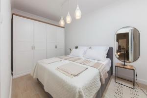 a white bedroom with a bed and a mirror at Spring Apartment in Perast