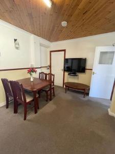 a dining room with a table and chairs and a television at Near Sea House Stay in Bangor