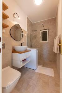 La salle de bains est pourvue d'un lavabo, de toilettes et d'un miroir. dans l'établissement Spring Apartment, à Perast