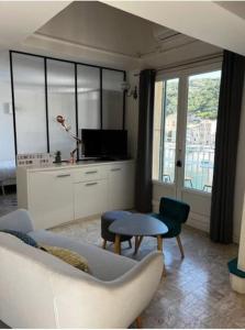 uma sala de estar com um sofá e uma mesa em Appartement duplex plein sud sur le port de Bonifacio em Bonifacio