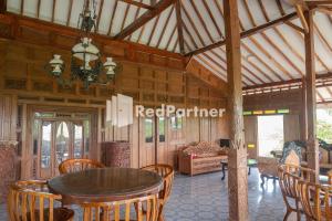 a room with a table and chairs in a house at Baron Hill Resort Gunung Kidul Mitra RedDoorz in Baron
