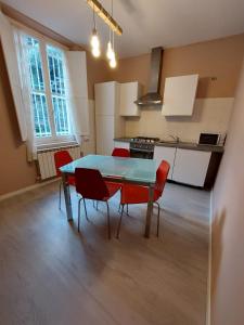 a kitchen with a blue table and red chairs at Casa del trogolo in Varazze