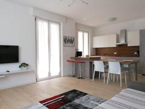 eine Küche und ein Wohnzimmer mit einem Tisch und Stühlen in der Unterkunft Casa vacanze Sissi in Arco