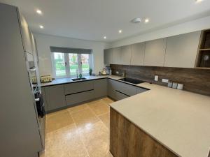 een grote keuken met witte kasten en een aanrecht bij Beautiful Countryside Home in Hereford