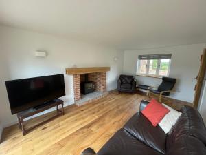 a living room with a couch and a fireplace at Beautiful Countryside Home in Hereford