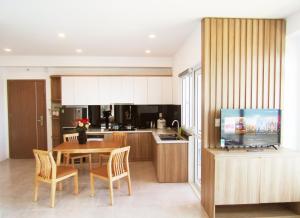 a kitchen and dining room with a table and a television at Sea House Nha Trang in Nha Trang