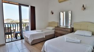 a hotel room with two beds and a balcony at Gumbet Hotel in Gümbet