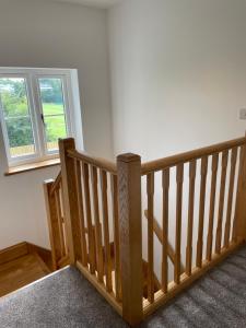 a wooden staircase in a room with a window at Beautiful Countryside Home in Hereford