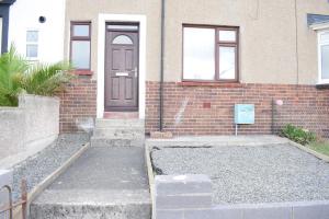 uma casa de tijolos com uma porta e escadas em frente em House Stay in Bangor North Wales em Bangor