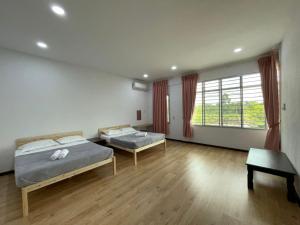 1 dormitorio con 2 camas y ventana grande en Wawasan Sweet Home - UTS Sibu, en Sibu