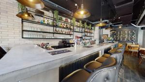 a bar in a restaurant with a counter and chairs at Block in Xlendi